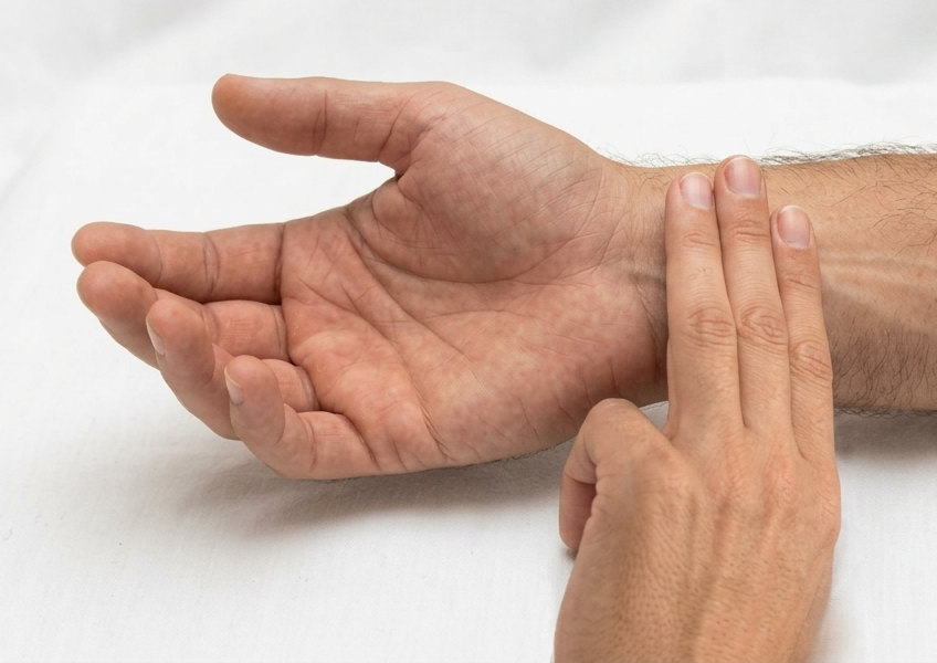 Acupuncturist performing pulse diagnosis on a patient's wrist