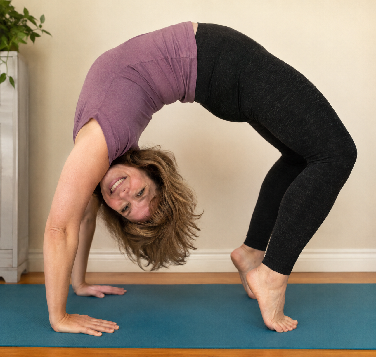 A woman stretching into a backbend on a yoga mat